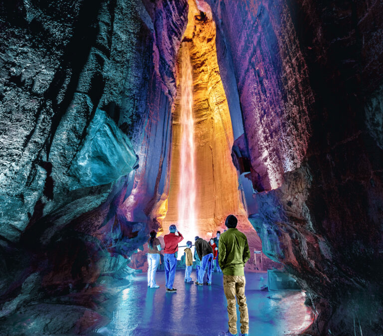 A group of people standing and looking at Ruby Falls waterfall in Ruby Falls Cave.