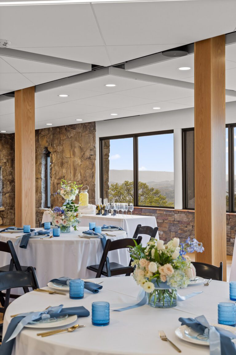 Tables are for a party with large windows behind showing a view of mountains.