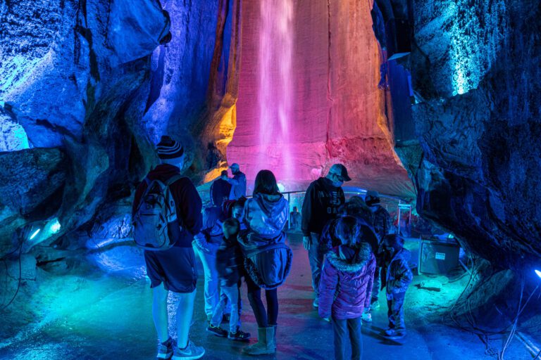 A group of people standing in front of Ruby Falls waterfall