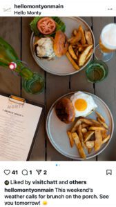 Two plates featuring brunch items and a menu sit on a table at a restaurant. 