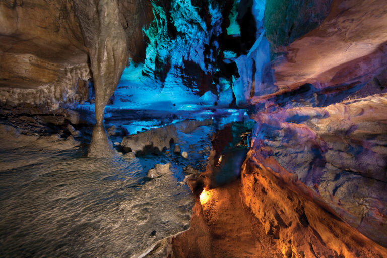Cavern trail inside Ruby Falls Cave. The trail is surrounded by limestone and geological formations hang from the ceiling about the trail.