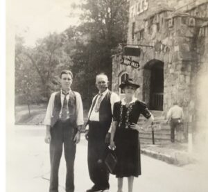 image of two men and one women standing near stone castle at Ruby Falls in the 1940s.
