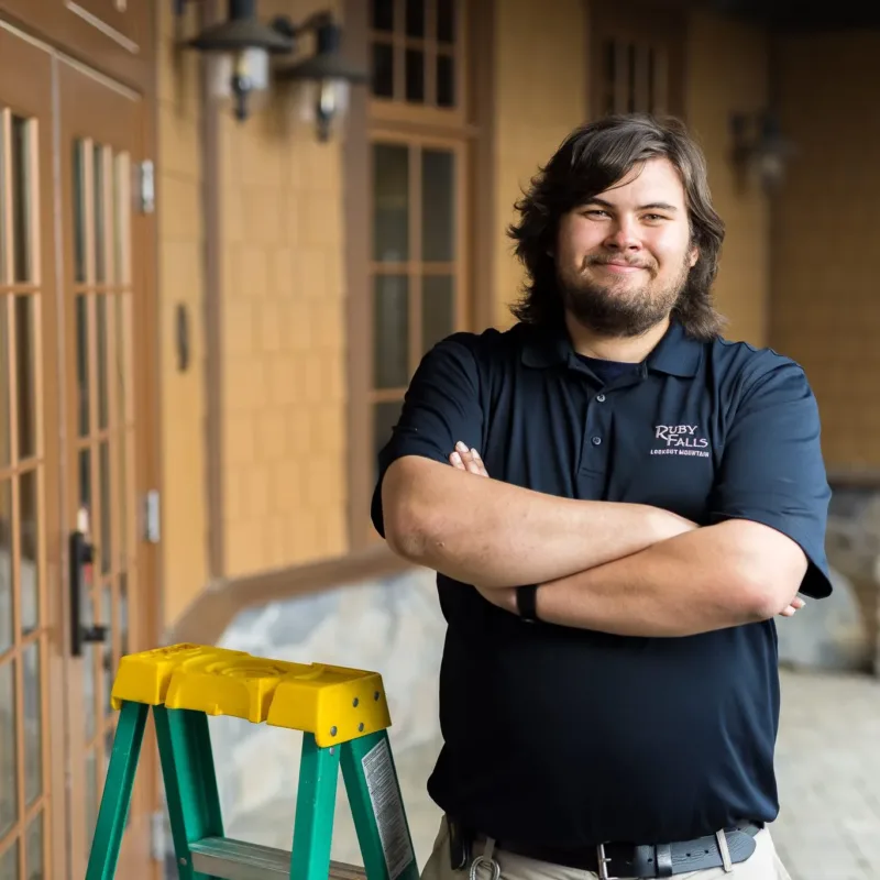 Ruby falls male employee standing with a ladder in front of the gift shop 